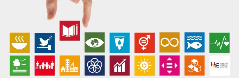 Eine Hand setzt zwischen bunte Kacheln, auf denen Icons zu den 7 Nachhaltigkeits-Zielen (SDGs) abgebildet sind, die Kachel mit dem Buch-Icon, das für hochwertige Bildung steht. | Quelle: 17ziele.de