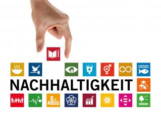 Eine Hand setzt zwischen bunte Kacheln, auf denen Icons zu den 7 Nachhaltigkeits-Zielen (SDGs) abgebildet sind, die Kachel mit dem Buch-Icon, das für hochwertige Bildung steht. | Vorlage zu den 17 Zielen: UN | Gestaltung: Heidelberg School of Education