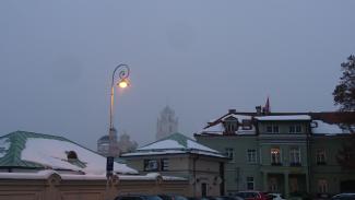 Das Bild zeigt schneebedeckte Häuser in Vilnius unter winterlichem Himmel.