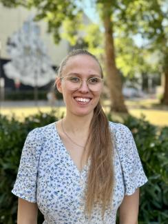 ZQ-Absolventin Laura Schweikert lächelnd auf dem grünen Campus Bergheim