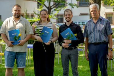 Das Bild zeigt die Preisträger:innen Anton Huber, Celine Schäfer und Marco Schäfer mit Prorektor Prof. Dr. Karl-Heinz Dammer. In der Hand eine gelbe Rose und die Urkunde. | Bild: PHHD