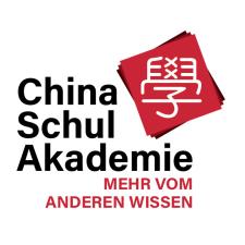 Das Logo der China-Schul-Akademie zeigt auf weißem Grund den schwarzen Schriftzug „China Schul Akademie“, darunter in Rot „MEHR VOM ANDEREN WISSEN“: Rechts oben chinesische Schriftzeichen auf rotem Grund.