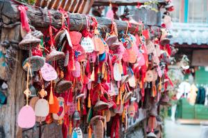 Foto aufgenommen am buddhistischen Puji-Tempel, in Lijiang, Provinz Yunnan. Die abgebildeten roten Holztäfelchen (auch: Ema) werden von Gläubigen mit kurzen Gesuchen und Gebeten - oft zum Bestehen von bevorstehenden Prüfungen oder Heilung von Krankheiten - beschriftet und in designierten Bereichen im Tempel aufgehängt. Bild: © Pixabay/Charlottees