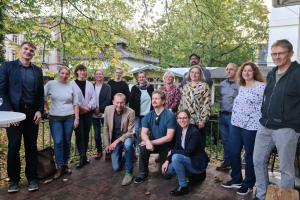 Gruppenfoto der Teilnehmenden des Auftakttreffens auf der von Bäumen gerahmten Terrasse der HSE.