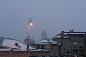 Das Bild zeigt schneebedeckte Häuser in Vilnius unter winterlichem Himmel.