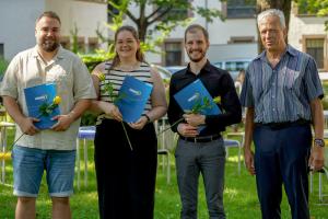 Das Bild zeigt die Preisträger:innen Anton Huber, Celine Schäfer und Marco Schäfer mit Prorektor Prof. Dr. Karl-Heinz Dammer. In der Hand eine gelbe Rose und die Urkunde. | Bild: PHHD