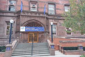 Das Bild zeigt Treppe und Eingang zum Teachers College mit einem blauen Begrüßungsbanner: "Forging a Future. First Gen Celebration Week"er