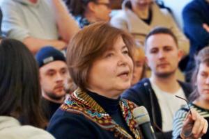 Prof. Dr. Havva Engin mit einem Mikrofon bei einer Diskussion, umgeben von Publikum.