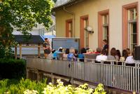 Die gut gefüllte der Terrasse der Heidelberg School of Education aus der Perspektive des Gartens mit Referent Matthias Heil vor dem Smartboard