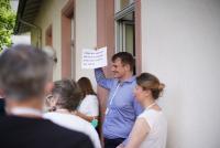 Dr. Florian Grafl beim ersten Cluster-Forum des Forschungs- und Transferclusters „Kulturelles Erbe und Kanonisierung von Wissen“ mit einem Blatt, auf dem zu lesen ist: „Dark Heritage und die Vermittlung von kulturellem Erbe in der Schule“