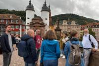 Prof. Dr. Hans Gebhardt mit Teilnehmenden des Stadtrundgangs auf der Alten Brücke in Heidelberg.