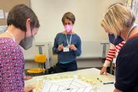 Teilnehmende des Panels „Nachhaltigkeit“ beim interaktiven Brainstorming an einem Tisch mit Kärtchen und Spinnennetz-Vorlage. Bild: © Heidelberg School of Education | Nicole Aeschbach