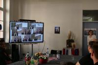 Christiane Wienand zeigt auf dem Smartboard Bilder aus Michael Haus' Amtszeit, hier eine Collage, die ihn beim Überreichen der Zeugnisse an die M. Ed.-Absolvent:innen zeigt.