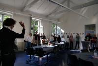 Michael Haus, von hinten zu sehen, hebt grüßend die Hand. Vor ihm im geschmückten Raum das HSE-Team.