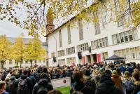 Der Heidelberger Uniplatz ist gefüllt mit Studierenden, die der Begrüßung durch die Rektorin lauschen. Rechts im Hintergrund die Neue Universität.