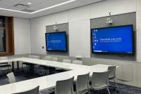 Kursraum in der Grace Dodge Hall des Teachers College. An den Wänden zwei Smartboards, davor weiße Tische und graue Stühle in U-Form.