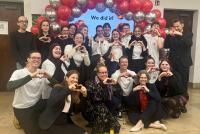 Gruppenfoto des Organisationsteams vor dem Ballonbogen; im Hintergrund der Schriftzug "We did it!"