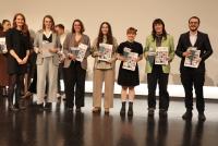 Prof. Dr. Silke Hertel mit Absolvent:innen auf der Bühne. Sie halten ihre Zeugnisse in den Händen.