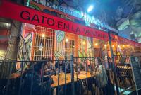 Chilenisches Nachtleben: Junge Menschen sitzen auf der Veranda einer bunten Kneipe.