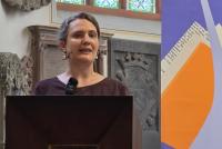 Wiebke Steinleitner bei ihrem Vortrag zur in der Peterskirche. Rechts das Roll-up zur Akademischen Mittagspause.