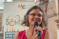 Dr. Christiane Wienand moderiert in der Peterskirche den Vortrag von Wiebke Steinleitner an. Hinter ihr das HSE-Roll-up.