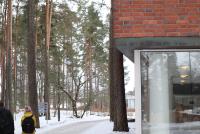 Das Bild zeigt einen Teil des Gebäudes der Universität Jyväskylä, der an einen verschneiten Wald angrenzt.
